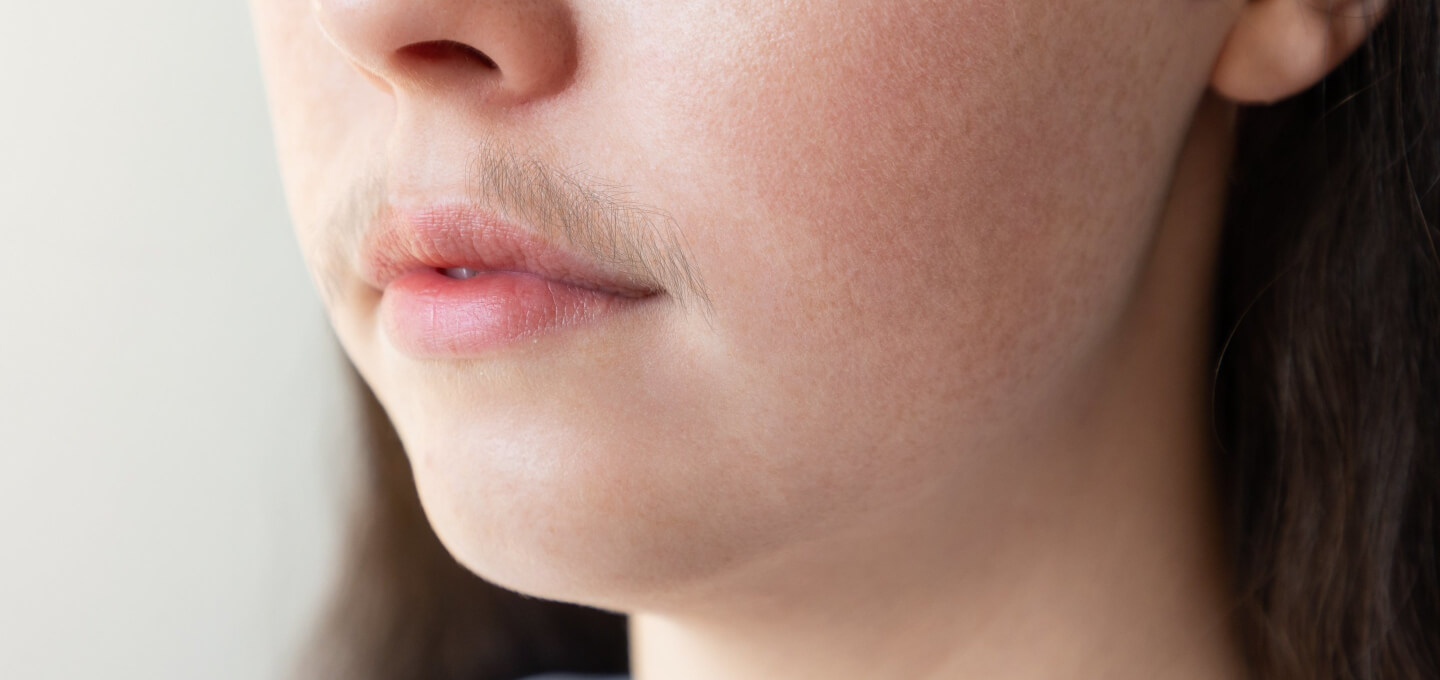 A close up of a woman's face with a mustache.