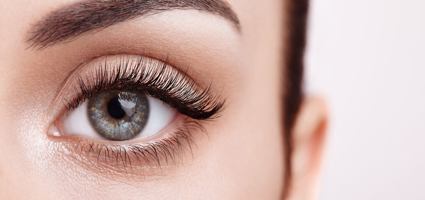 A close up of a woman's eye with long lashes.