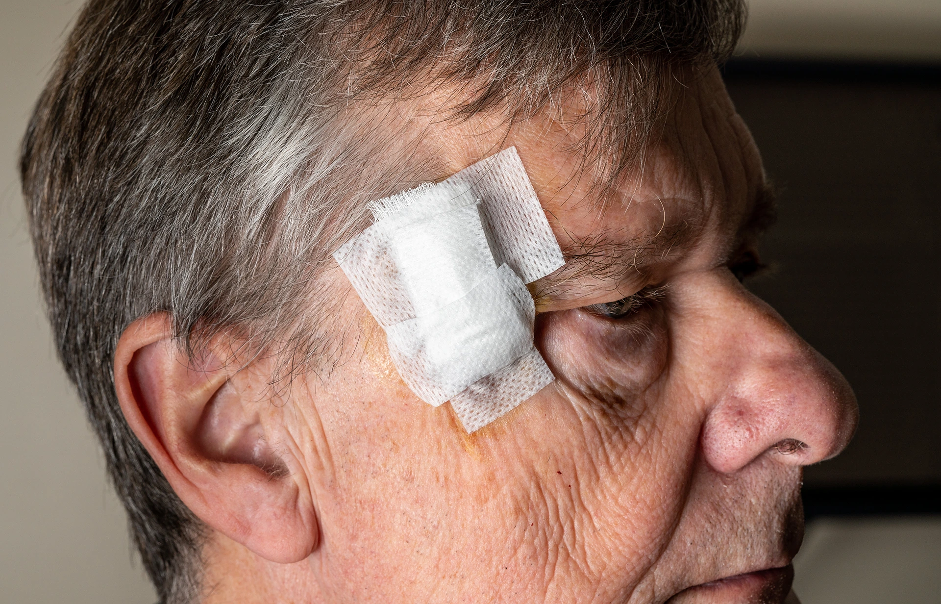 A man with a bandaged wound on his forehead.