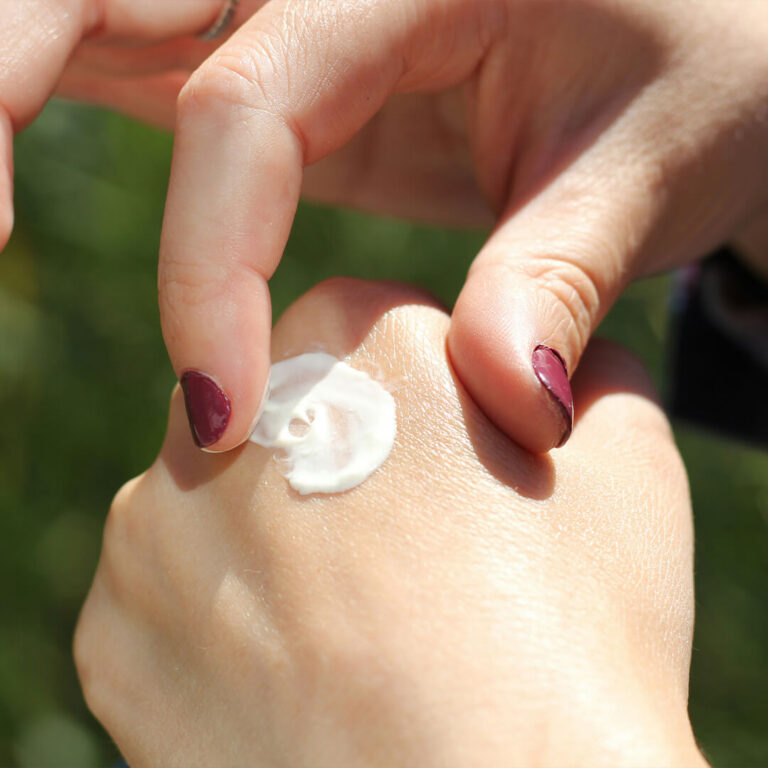Woman applying cream on hands