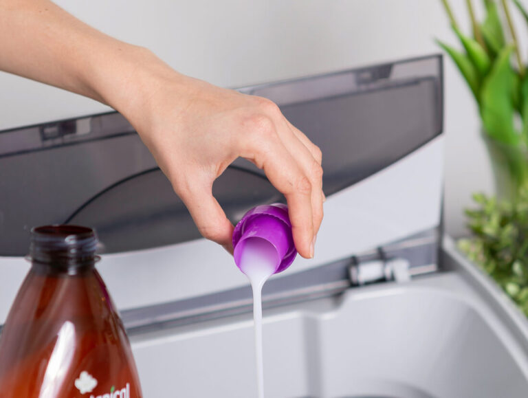 Pouring laundry detergent in washing machine